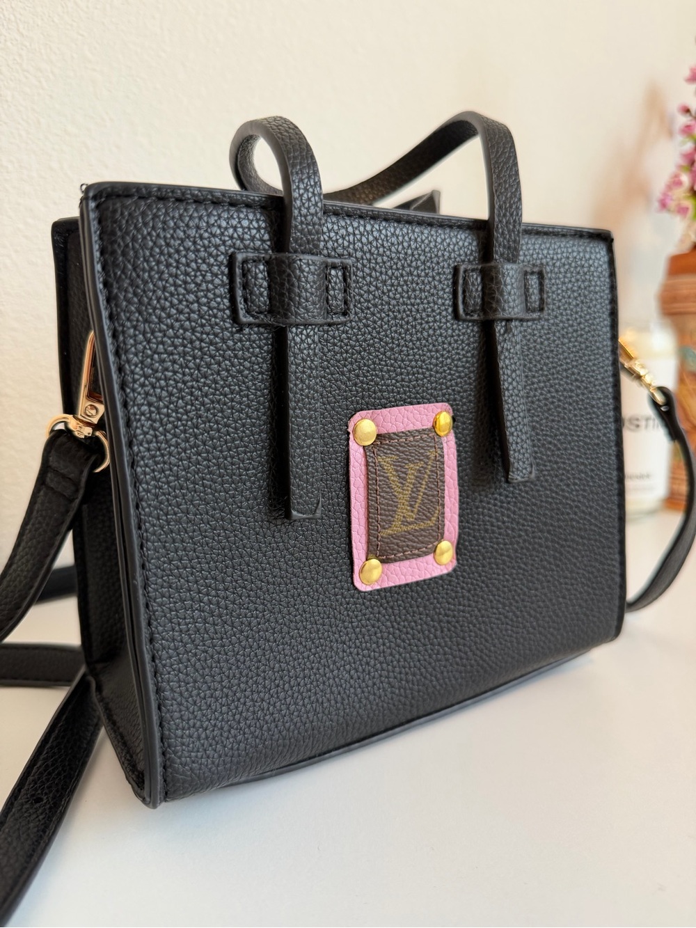 Black Women’s Pebbled Leather Crossbody Bag with Louis Vuitton patch.
